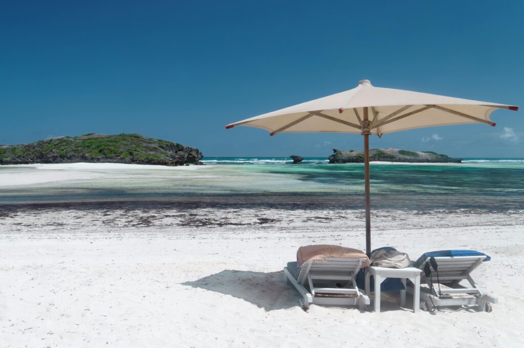 Romantic Croatia getaways on a pristine Mediterranean beach with white sand, turquoise waters, and relaxing lounge chairs under a parasol.